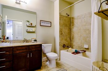 Spacious bathrooms with tiled floors and shower surrounds